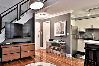 Kleines Klassisches Wohnzimmer ohne Kamin, im Loft-Stil mit grauer Wandfarbe, hellem Holzboden, TV-Wand und beigem Boden in Toronto