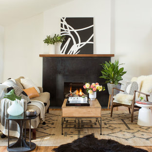 This is an example of a scandinavian living room in Denver with white walls, light hardwood flooring, a standard fireplace and no tv.