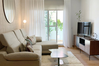 Modelo de salón abierto moderno sin chimenea con paredes beige, suelo de madera en tonos medios, televisor en una esquina, suelo marrón, papel pintado y papel pintado