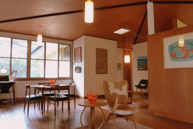 Idées déco pour un salon rétro de taille moyenne avec un mur blanc et un sol en bois brun.