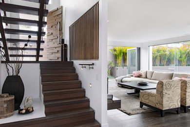 Esempio di un soggiorno minimal di medie dimensioni e aperto con pareti bianche, pavimento in laminato e pavimento marrone