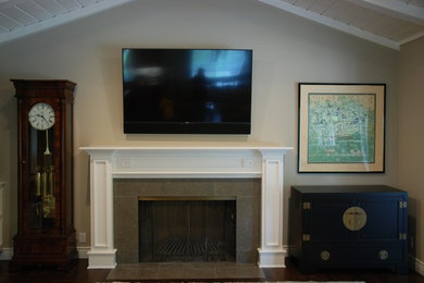 サンフランシスコにある低価格の小さなトラディショナルスタイルのおしゃれなリビング (ベージュの壁、無垢フローリング、標準型暖炉、タイルの暖炉まわり、壁掛け型テレビ、グレーの床) の写真