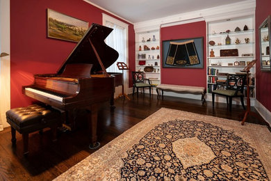 Example of a large classic enclosed dark wood floor and brown floor living room design in Boston with a music area and red walls