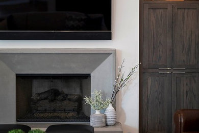 アトランタにある高級な中くらいなコンテンポラリースタイルのおしゃれなリビングロフト (白い壁、無垢フローリング、標準型暖炉、コンクリートの暖炉まわり、茶色い床) の写真