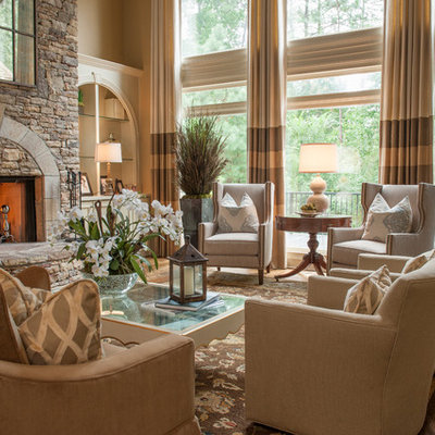 Inspiration for a mid-sized timeless formal and open concept medium tone wood floor and brown floor living room remodel in Atlanta with a standard fireplace, a stone fireplace, beige walls and no tv