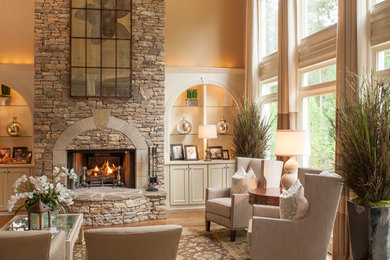 Living room - mid-sized traditional formal and open concept medium tone wood floor and brown floor living room idea in Atlanta with beige walls, a standard fireplace, a stone fireplace and no tv