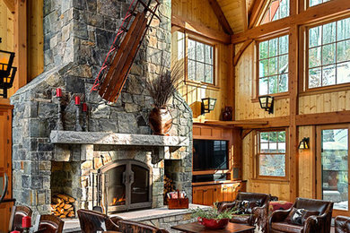 Large mountain style open concept dark wood floor living room photo in Burlington with brown walls, a standard fireplace, a stone fireplace and a tv stand