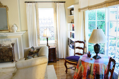 Esempio di un grande soggiorno classico chiuso con pareti gialle, parquet chiaro e camino classico
