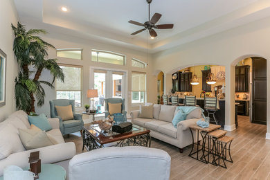 Example of a large beach style open concept porcelain tile living room design in Houston with beige walls