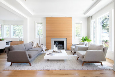 Repräsentatives, Fernseherloses, Offenes, Mittelgroßes Modernes Wohnzimmer mit weißer Wandfarbe, braunem Holzboden, Kamin, gefliester Kaminumrandung und braunem Boden in Vancouver