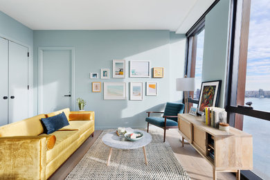 Trendy light wood floor and beige floor living room photo in New York with blue walls