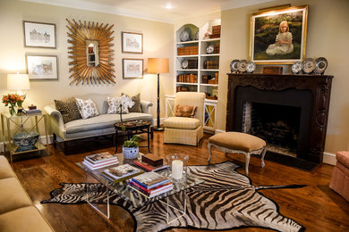 This is an example of a medium sized eclectic open plan living room with beige walls, medium hardwood flooring, a standard fireplace, a wooden fireplace surround, no tv and brown floors.
