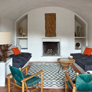 Imagen de salón para visitas arcos, ecléctico, con paredes blancas, suelo de baldosas de terracota, todas las chimeneas y marco de chimenea de yeso