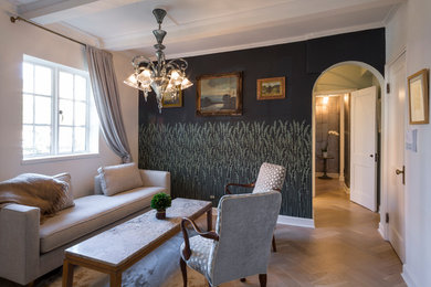 Foto de salón para visitas cerrado bohemio de tamaño medio sin televisor con paredes negras, suelo de madera clara, estufa de leña y marco de chimenea de piedra
