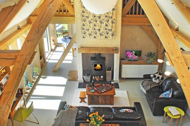 Photo of a beach style open plan living room in Devon with light hardwood flooring and a wood burning stove.
