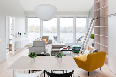 Идея дизайна: парадная, открытая гостиная комната среднего размера в скандинавском стиле с белыми стенами, светлым паркетным полом, телевизором на стене и бежевым полом без камина