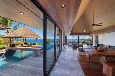 Esempio di un grande soggiorno tropicale aperto con pareti beige, parquet scuro, TV autoportante e pavimento marrone