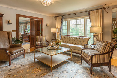 Imagen de salón para visitas cerrado tradicional de tamaño medio sin chimenea y televisor con paredes grises, suelo de madera clara y suelo marrón