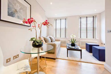 Photo of a large contemporary enclosed living room in London with painted wood flooring and beige floors.