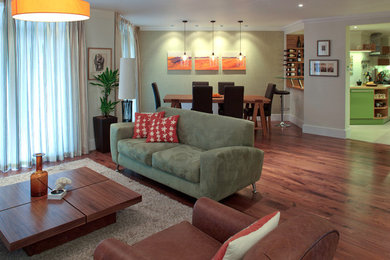 Photo of a medium sized contemporary open plan living room in London with beige walls, dark hardwood flooring and a freestanding tv.