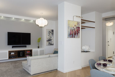 Diseño de salón para visitas abierto minimalista grande con televisor colgado en la pared, paredes blancas y suelo de madera clara