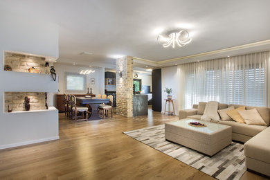 Aménagement d'un salon contemporain de taille moyenne et ouvert avec un mur blanc et un sol en bois brun.
