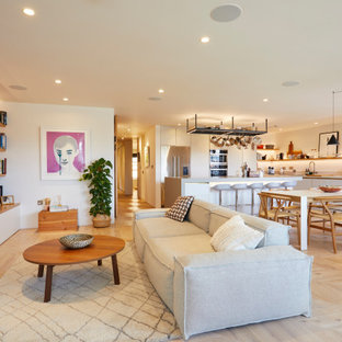 Inspiration for a medium sized contemporary open plan living room in London with white walls, no fireplace, a wall mounted tv, beige floors and light hardwood flooring.