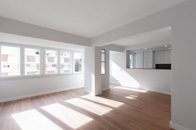 Foto de salón minimalista con paredes grises, suelo laminado y suelo marrón