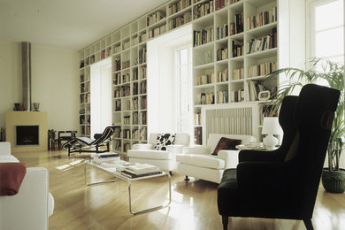 На фото: гостиная комната:: освещение в стиле модернизм с с книжными шкафами и полками, белыми стенами и светлым паркетным полом