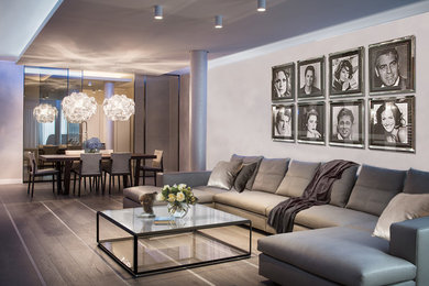 Esempio di un grande soggiorno contemporaneo aperto con pareti beige e parquet chiaro