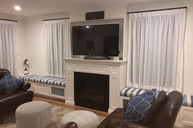 Imagen de salón clásico con paredes blancas, suelo de madera clara y televisor independiente
