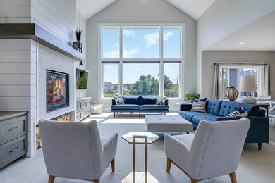 This is an example of a large contemporary formal open plan living room in Grand Rapids with white walls, carpet, a standard fireplace, a tiled fireplace surround, a wall mounted tv and beige floors.
