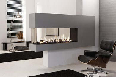 Photo of a large contemporary enclosed living room in London with a two-sided fireplace, a stone fireplace surround and feature lighting.