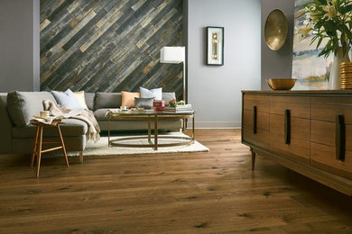 Imagen de salón para visitas abierto retro de tamaño medio sin chimenea con paredes grises, suelo de madera en tonos medios y suelo marrón