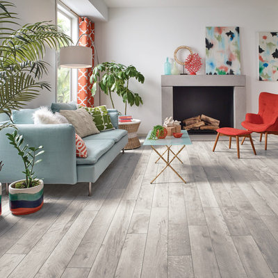 Example of a large trendy formal and open concept light wood floor and gray floor living room design in DC Metro with white walls, a standard fireplace, a concrete fireplace and no tv