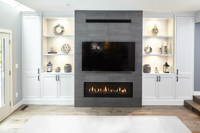 Living room - mid-sized modern formal and open concept medium tone wood floor and brown floor living room idea with white walls, a standard fireplace, a tile fireplace and a wall-mounted tv