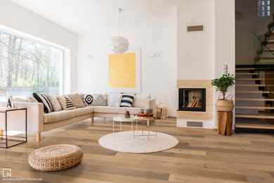 Inspiration for a modern beige floor and medium tone wood floor living room remodel with white walls, a corner fireplace and a stone fireplace