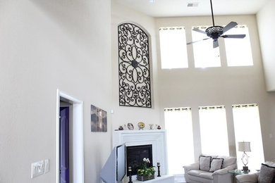 ヒューストンにあるトラディショナルスタイルのおしゃれなLDK (白い壁、濃色無垢フローリング、標準型暖炉、漆喰の暖炉まわり、据え置き型テレビ) の写真