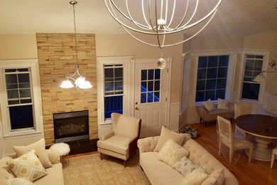 Example of a mid-sized mountain style formal and open concept medium tone wood floor living room design in Boston with white walls, a standard fireplace, a stone fireplace and no tv