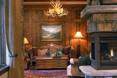 На фото: большая парадная, открытая гостиная комната в стиле рустика с бежевыми стенами, полом из сланца, двусторонним камином и фасадом камина из камня