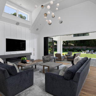 Offenes Klassisches Wohnzimmer mit weißer Wandfarbe, braunem Holzboden, Gaskamin, Wand-TV, braunem Boden, gewölbter Decke, Holzdielendecke und Wandpaneelen in San Francisco