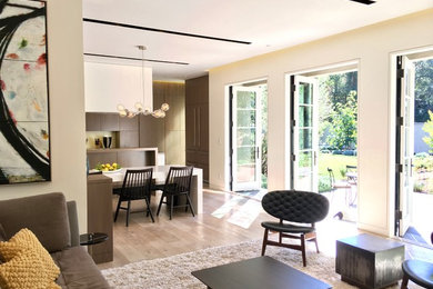 Inspiration pour un grand salon minimaliste ouvert avec un sol en bois brun et un mur beige.