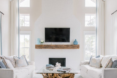 Inspiration for a large coastal open plan living room in Jacksonville with a standard fireplace, a brick fireplace surround, grey walls, carpet, a wall mounted tv and blue floors.