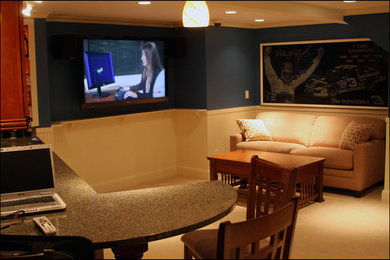 Modelo de cine en casa cerrado con paredes beige, moqueta y televisor colgado en la pared