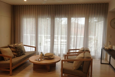 Diseño de salón contemporáneo de tamaño medio con suelo de madera clara