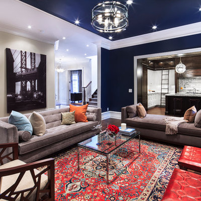Large trendy open concept medium tone wood floor and brown floor living room photo in Toronto with blue walls, a standard fireplace and a wall-mounted tv
