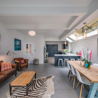 This is an example of a scandi open plan living room in London with white walls, concrete flooring and grey floors.