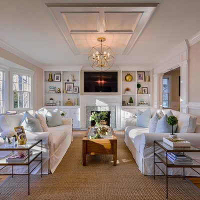 Example of a mid-sized transitional enclosed medium tone wood floor living room design in New York with a standard fireplace, a wall-mounted tv and beige walls