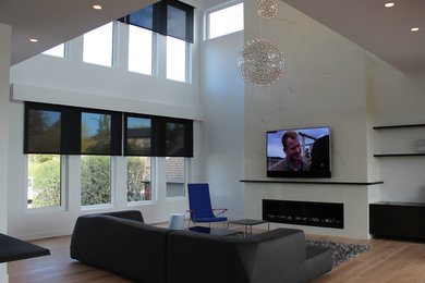 Example of a large trendy open concept light wood floor and beige floor living room design in Calgary with white walls, a ribbon fireplace, a tile fireplace and a wall-mounted tv
