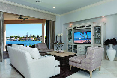 マイアミにあるラグジュアリーな中くらいな地中海スタイルのおしゃれなLDK (青い壁、トラバーチンの床、暖炉なし、据え置き型テレビ) の写真